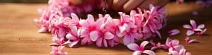 a pink flower necklace resting on a table